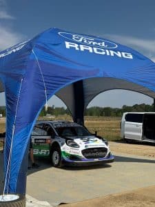The M-Sport Ford Puma Rally1 under the Ford Racing awning at the airfield beside the Goodwood Festival of Speed 2026